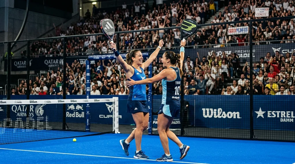 Pareja femenina celebrando un punto en una pista de pádel del Premier Padel con público de fondo
